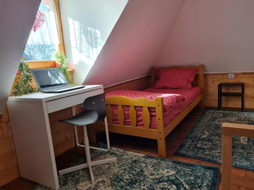 a small bedroom with a desk and a laptop computer at Art Village in Kremna