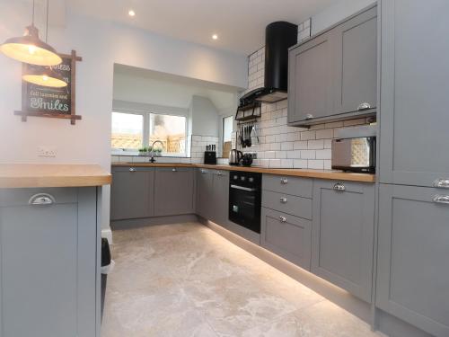 a large kitchen with gray cabinets and appliances at 23 Ryden Avenue in Cleveleys