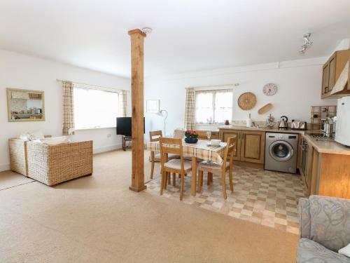 a kitchen and living room with a table and chairs at Flink's Barn in Great Dunmow