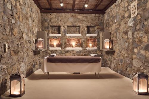 a bathroom with a bath tub in a room with stone walls at Villa Petrolefko By Ethos Hospitality in Ornos