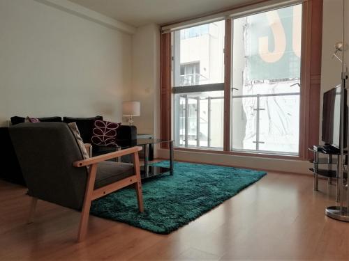 a living room with a couch and a chair and a rug at Still Life Old Street Executive in London