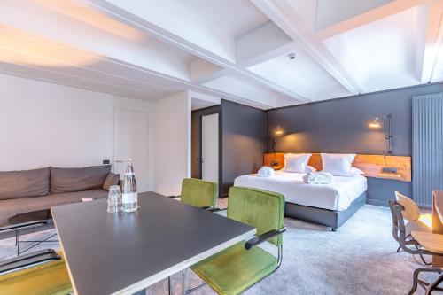a hotel room with a bed and a couch at Totem, Friendly Hotel & Spa in Flaine
