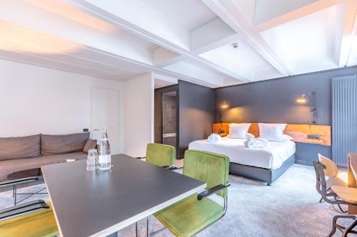 a hotel room with a bed and a couch at Totem, Friendly Hotel & Spa in Flaine