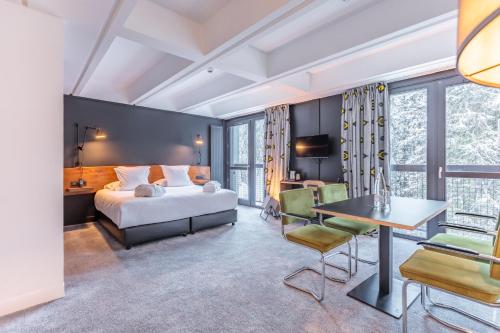 a hotel room with a bed and a desk at Totem, Friendly Hotel & Spa in Flaine