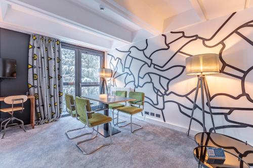 a room with a table and chairs and a mural at Totem, Friendly Hotel & Spa in Flaine