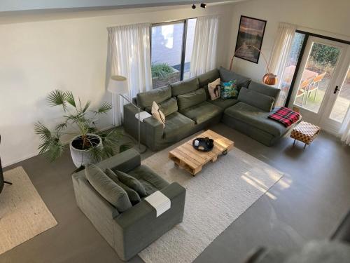 a living room with a couch and a table at Luxe vakantiehuis met sauna De Barn Bergen in Bergen
