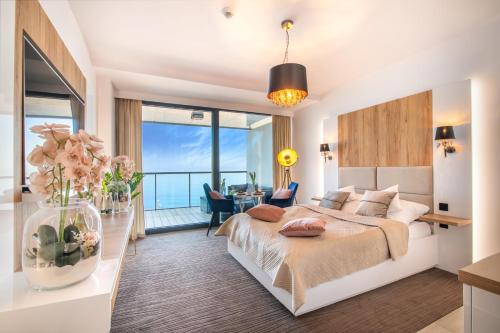 a bedroom with a large bed with a view of the ocean at NORTH Apartments, SunSetView 507 in Kołobrzeg