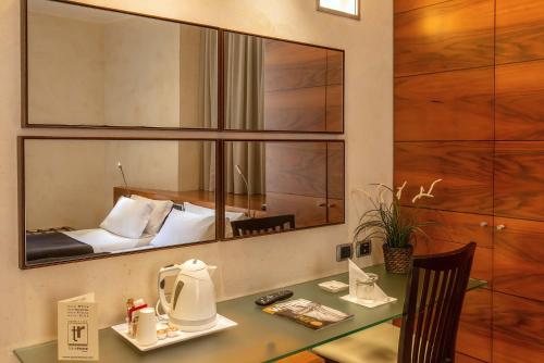 Habitación con escritorio, cama y espejo. en Hotel Tritone, en Roma