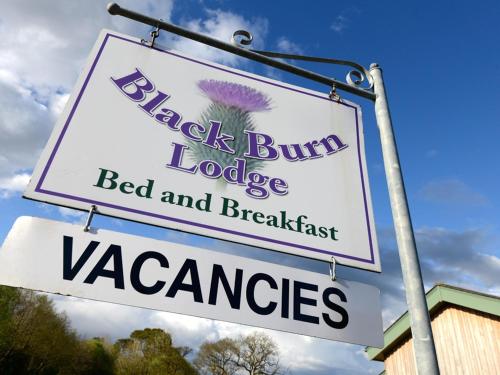 een bord voor een bed and breakfast restaurant bij Black Burn Lodge B & B in Newcastleton