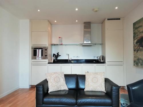 a living room with a couch and a kitchen at Still Life St Paul's Executive in London