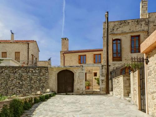 an old stone house with a stone driveway at Arcus Suites in Argyroupolis