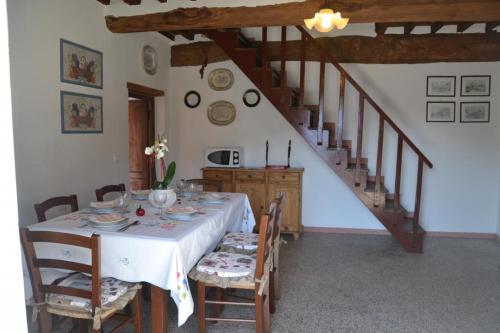 a dining room with a table and a staircase at Nel Colle in Valdottavo