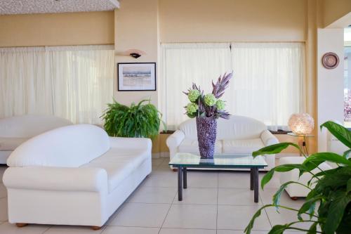 a living room with two white chairs and a table at Hotel Piccadilly in Bellaria-Igea Marina