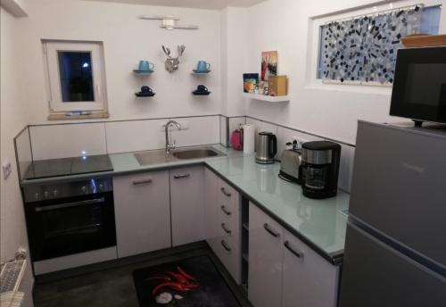 a kitchen with a counter and a sink and a refrigerator at Ferienwohnung Hirmer in Zirndorf