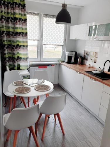 a kitchen with a white table and chairs at POKOJE GOŚCINNE UZDROVISCO CIEPLICE in Jelenia Góra