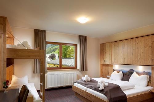 a bedroom with a bed with two teddy bears on it at Hotel der Wolkensteinbär in Bramberg am Wildkogel