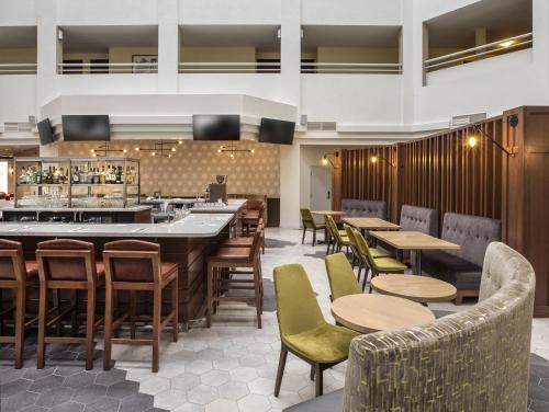 a restaurant with tables and chairs and a bar at Holiday Inn Montreal Longueuil by IHG in Longueuil
