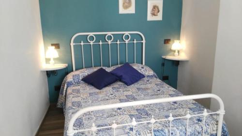 een slaapkamer met een bed met een blauwe muur bij ''SAPORE DI PROVENZA'' Sole Mare Quiete in Terzorio