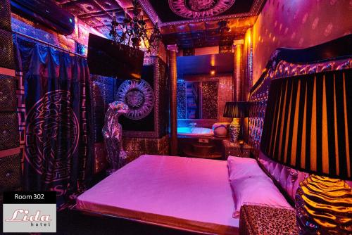 a room with a bed in a room with purple lights at Lida Hotel in Athens
