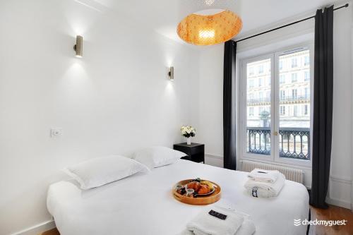 une chambre avec un lit avec un bol de fruits dessus dans l'établissement Splendid apartment - 2BR-6P - Place des Vosges, à Paris