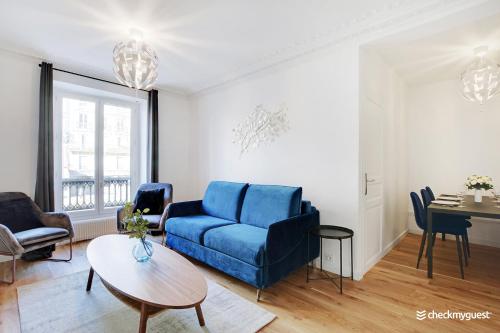 un salon avec un canapé bleu et une table dans l'établissement Splendid apartment - 2BR-6P - Place des Vosges, à Paris