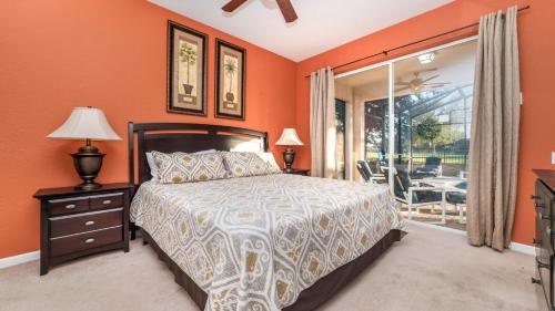 a bedroom with orange walls and a bed and a window at Luxury Contemporary Style Villa on Windsor Hills Resort, Orlando Villa 5006 in Orlando