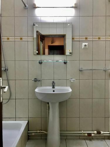a bathroom with a sink and a mirror and a tub at Hotel Casa Pelerinul in Durau