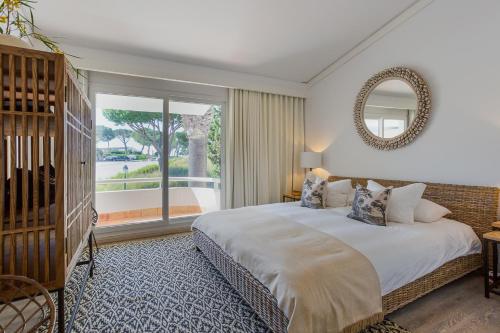 a bedroom with a large bed and a large window at M&M Home in Quinta do Lago