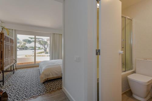 a bedroom with a bed and a bathroom with a toilet at M&M Home in Quinta do Lago