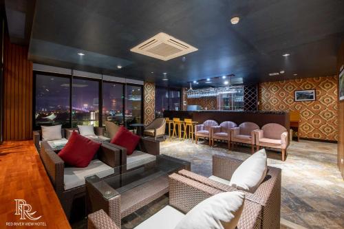a room with couches and a bar with a view at Red River View Hotel in Lao Cai