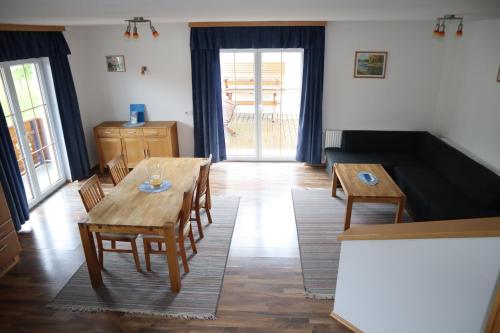 a living room with a wooden table and chairs at Tremlhof in Unterach am Attersee