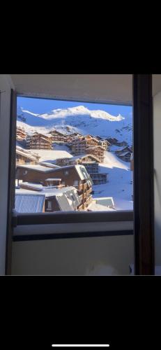 - une vue sur la ville depuis une fenêtre enneigée dans l'établissement Charmant T2 montagne en étage élevé., à Val Thorens