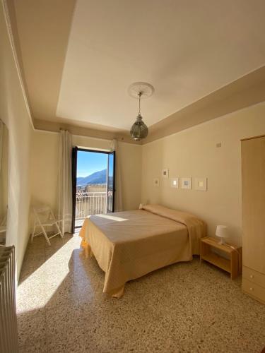 a bedroom with a bed and a large window at Maria Guesthouse in Morano Calabro