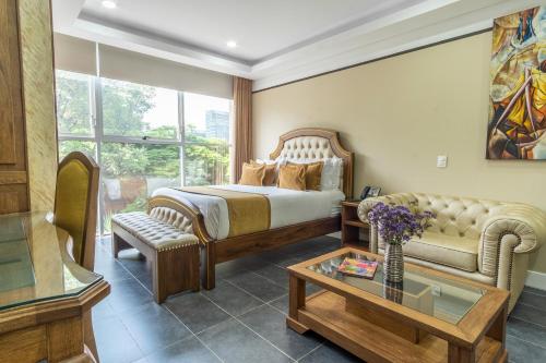 a bedroom with a bed and a couch and a table at Hotel Du Parc in Medellín