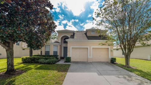 a large house with a driveway and trees at Luxury Villa with Private Pool on Windsor Hills Resort, Orlando Villa 4857 in Orlando