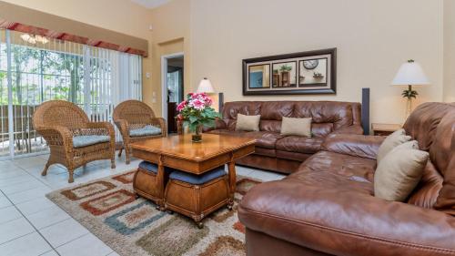 a living room with a leather couch and a table at Luxury Villa with Private Pool on Windsor Hills Resort, Orlando Villa 4857 in Orlando