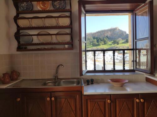 a kitchen with a sink and a window with a view at villa Zinovia in Líndos