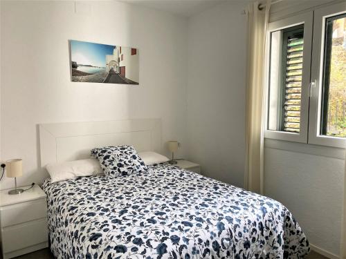 una camera da letto con un letto con un piumone bianco e nero di MARQUINA - Apartamento con fantásticas vistas al mar a Cadaqués