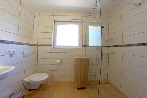 a bathroom with a toilet and a sink and a shower at WB2 Dat luette Hus in Dorum