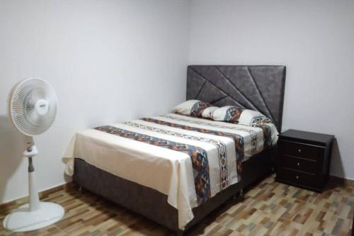 a bedroom with a bed and a fan at Piso 3-Apartment near to Cali airport in Palmira