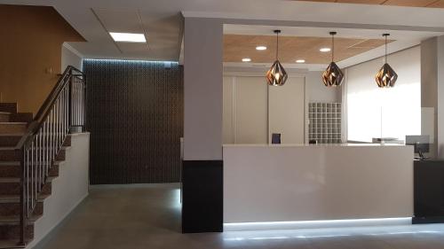 a lobby with a white counter and a staircase at Hotel Castilla in Albacete