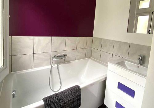 a bathroom with a bath tub and a sink at Appartement spacieux centre Aix les Bains in Aix-les-Bains