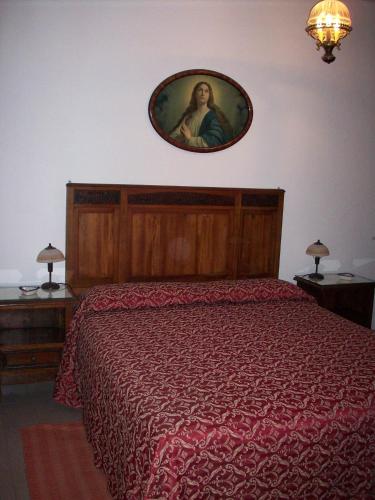 a bedroom with a bed with a picture on the wall at Hotel La Riva in Giardini Naxos