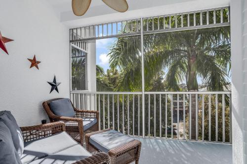 a screened in porch with chairs and a large window at Sunshine on My Shoulders in Marco Island