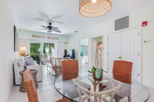 a living room with a glass table and chairs at Sunshine on My Shoulders in Marco Island