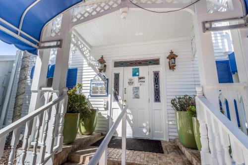 a front door of a white house with green plants at Sunshine on My Shoulders in Marco Island