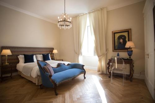 a bedroom with a bed and a blue chair at GMarconi Suites in Campobasso
