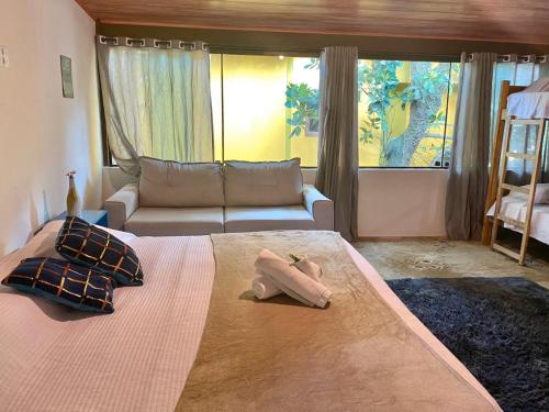 a bedroom with a large bed and a couch at Vila Pequeá Pousada Ilhabela in Ilhabela