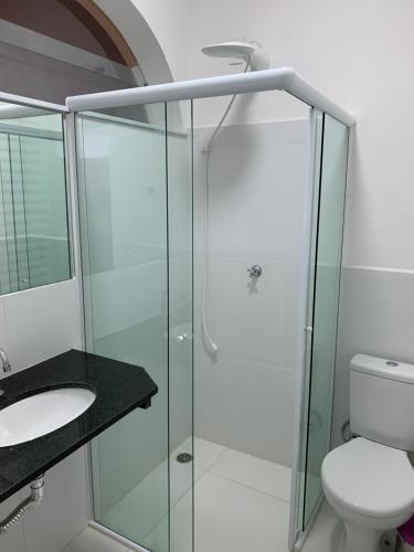 a bathroom with a glass shower and a toilet at Viva Barê Pousada in São Sebastião