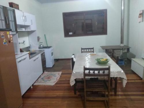 uma cozinha com uma mesa e uma cozinha com uma mesa e cadeiras em Casa de Campo - Cambará do Sul em Cambará
